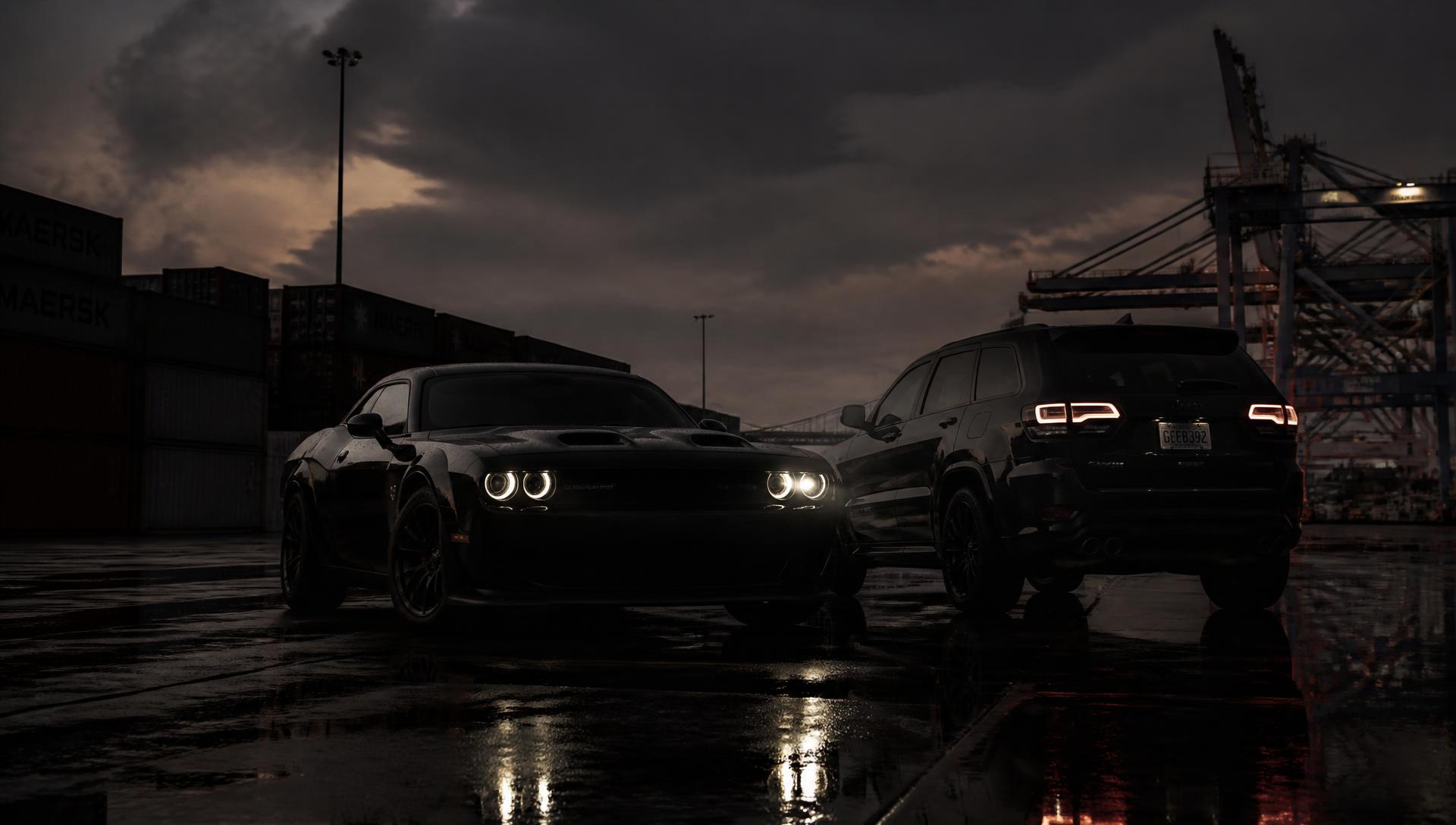 American performance car and luxury SUV at a U.S. export port at dusk